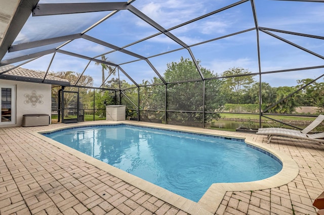 view of pool with a lanai, a patio, and a water view