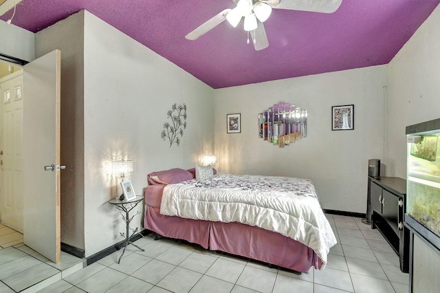 bedroom featuring ceiling fan, light tile patterned flooring, and a textured ceiling