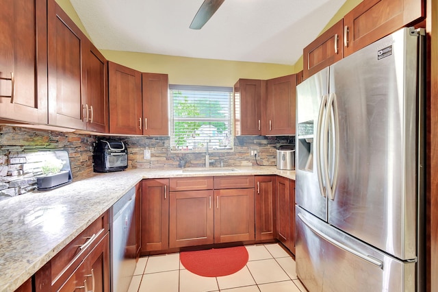 kitchen featuring ceiling fan, light tile patterned floors, sink, tasteful backsplash, and appliances with stainless steel finishes