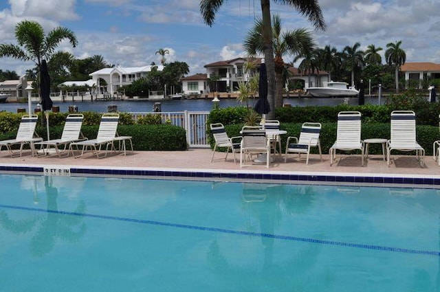 view of pool with a patio and a water view