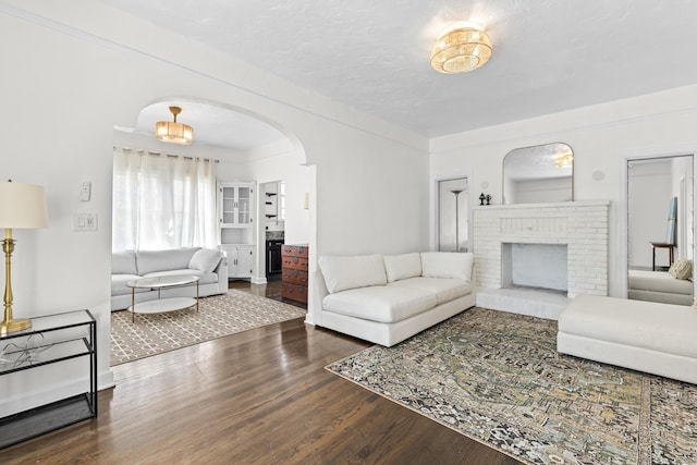435 35th St, West Palm Beach, FL 33407 - living area featuring arched walkways, wood finished floors, and a brick fireplace