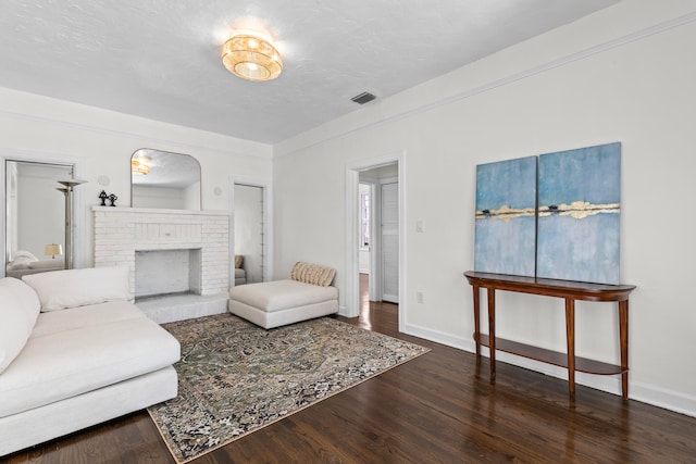 living room with a fireplace, hardwood / wood-style floors, and a textured ceiling