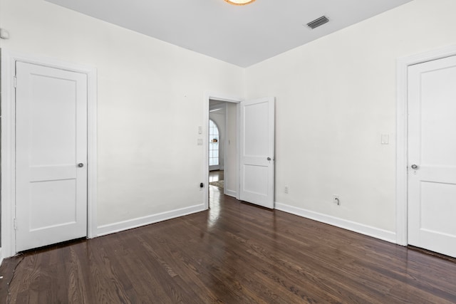 unfurnished bedroom with dark hardwood / wood-style floors