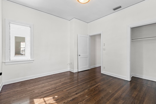 unfurnished bedroom featuring a closet and dark wood-type flooring