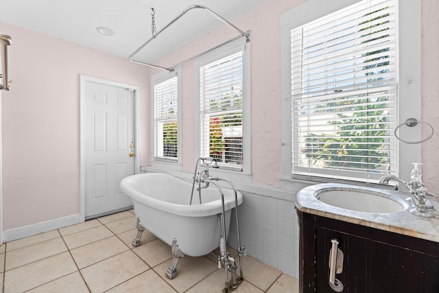 bathroom with tile patterned flooring, a bathtub, and vanity