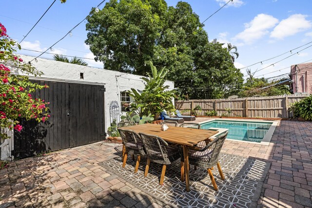435 35th St, West Palm Beach, FL 33407 - view of patio with outdoor dining area, a fenced in pool, and fence
