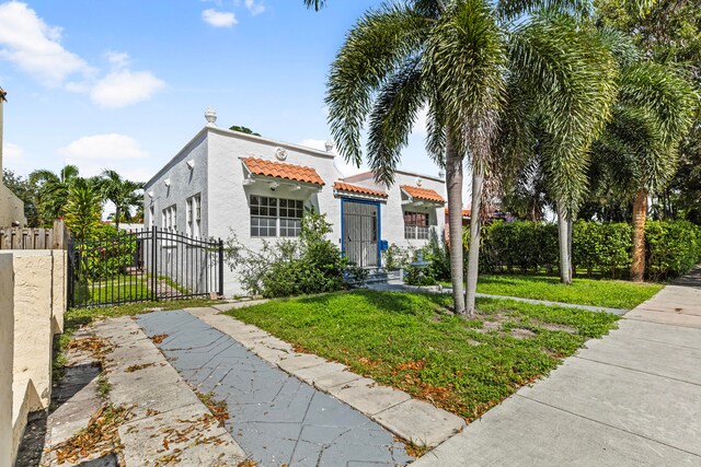 mediterranean / spanish house featuring a front lawn