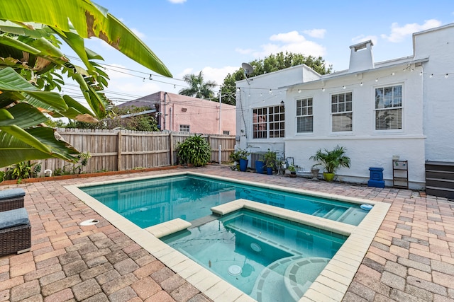 view of swimming pool featuring an in ground hot tub and a patio