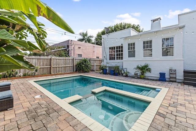 435 35th St, West Palm Beach, FL 33407 - view of swimming pool featuring a patio, a fenced backyard, and a pool with connected hot tub