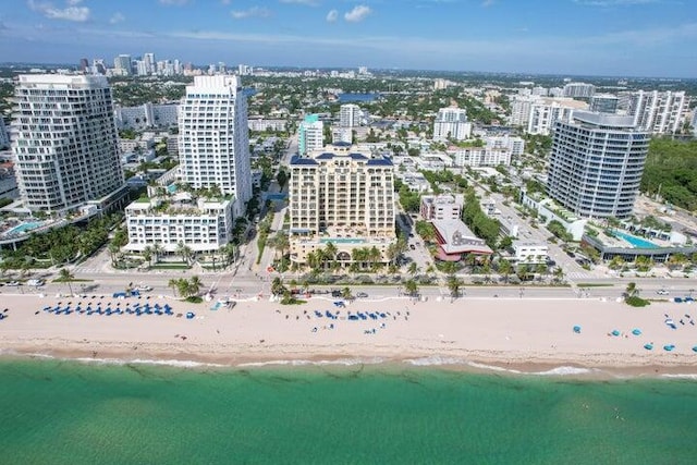 drone / aerial view featuring a water view and a view of the beach