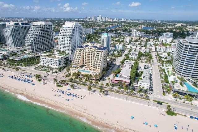 birds eye view of property with a water view and a beach view