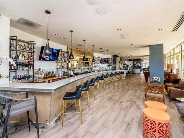 bar featuring decorative light fixtures and light hardwood / wood-style floors