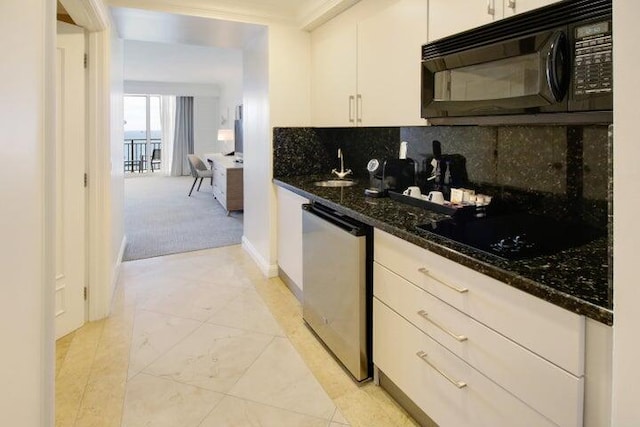 kitchen featuring decorative backsplash, white cabinetry, black appliances, dark stone countertops, and light carpet