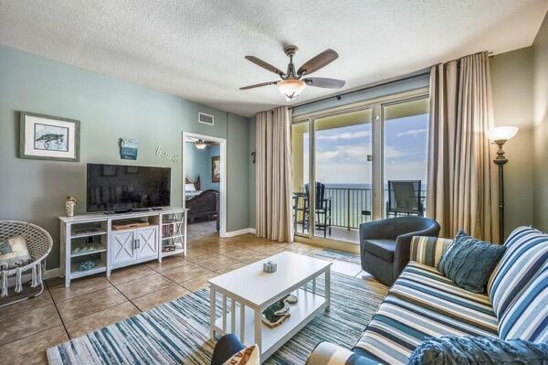 tiled living room featuring a textured ceiling and ceiling fan