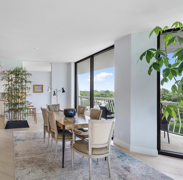 dining area featuring floor to ceiling windows and baseboards