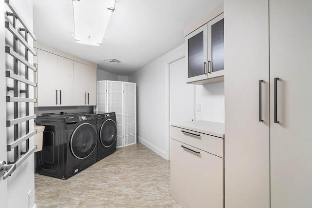 laundry area featuring washer and dryer, cabinet space, and visible vents