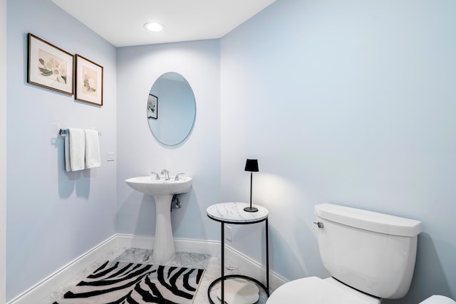 bathroom featuring toilet and baseboards