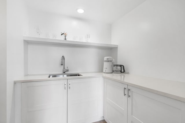 bar with white cabinets and sink