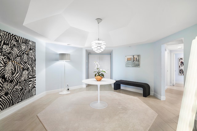 dining space featuring light hardwood / wood-style flooring and a notable chandelier