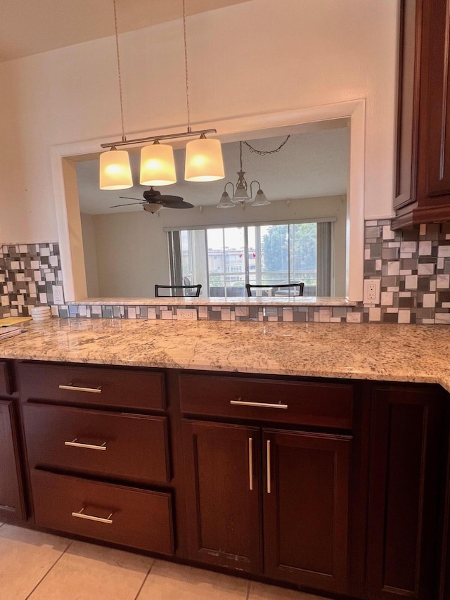 kitchen featuring dark brown cabinetry, decorative backsplash, ceiling fan, light tile patterned flooring, and light stone counters