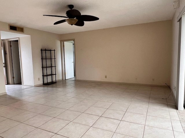 tiled spare room featuring ceiling fan