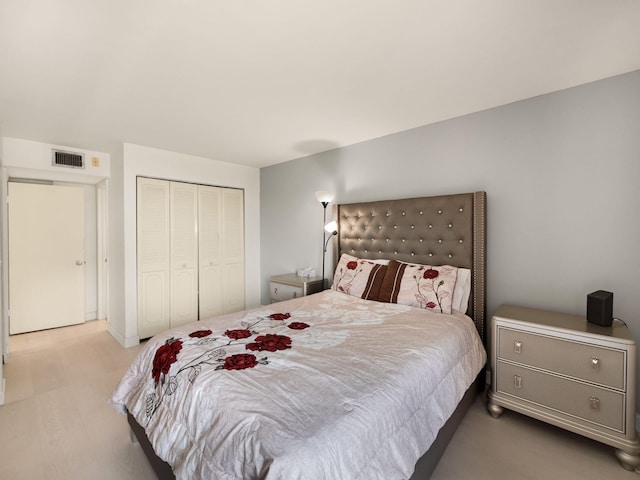 bedroom featuring a closet, visible vents, and wood finished floors