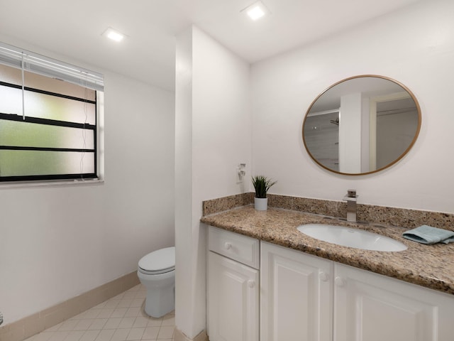 bathroom with tile patterned flooring, vanity, toilet, and baseboards