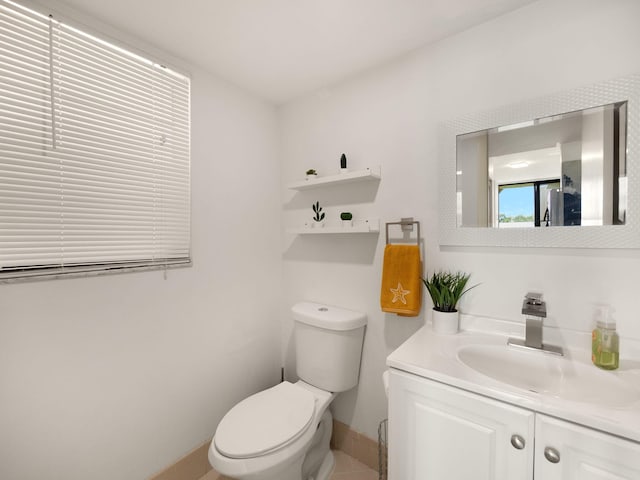 bathroom featuring toilet, baseboards, and vanity