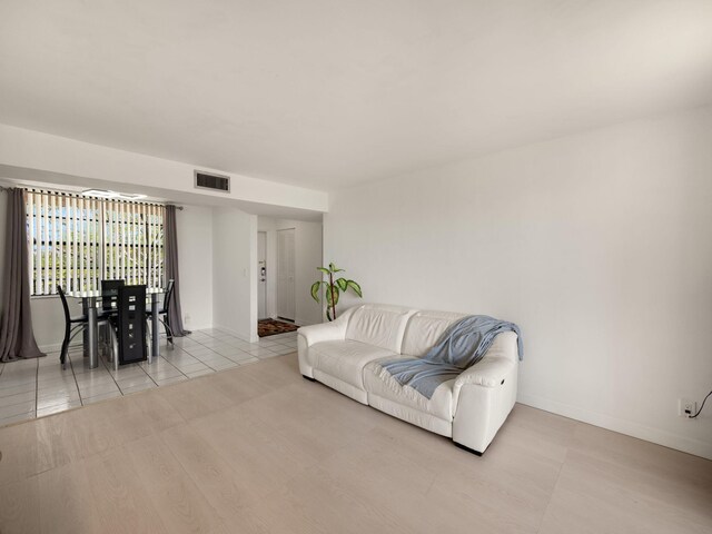 tiled living area featuring visible vents and baseboards