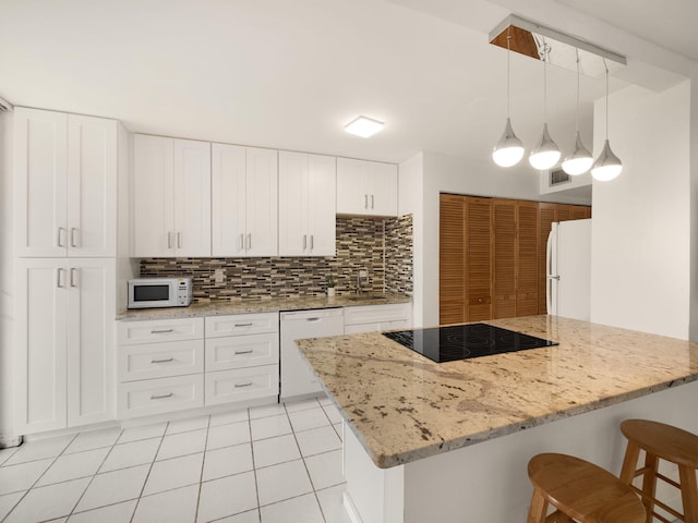 kitchen with white cabinets, tasteful backsplash, white appliances, and light tile patterned floors