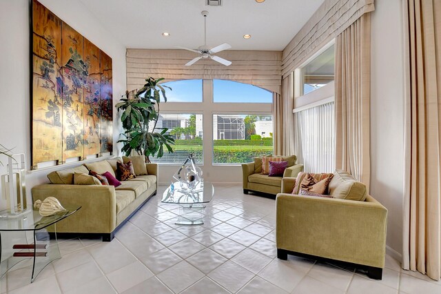 living room featuring light tile patterned floors, ceiling fan, recessed lighting, visible vents, and a towering ceiling