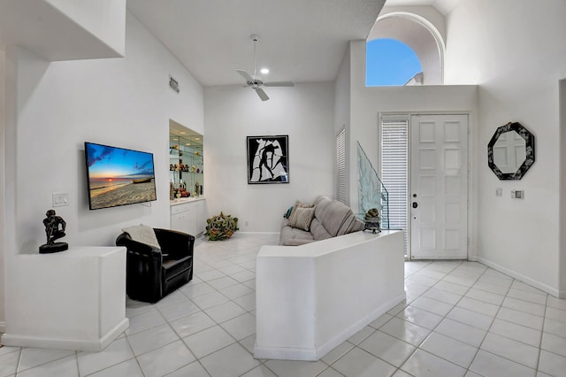 living room featuring light tile patterned flooring, a high ceiling, and ceiling fan