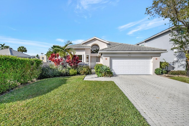 single story home with a garage and a front lawn