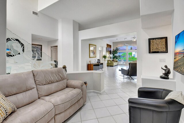 living area featuring visible vents, ceiling fan, baseboards, and light tile patterned floors