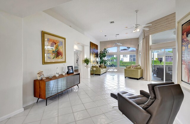 living area with baseboards, visible vents, a ceiling fan, and light tile patterned flooring