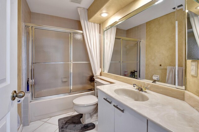 full bathroom with shower / bath combination with glass door, visible vents, toilet, vanity, and tile patterned flooring