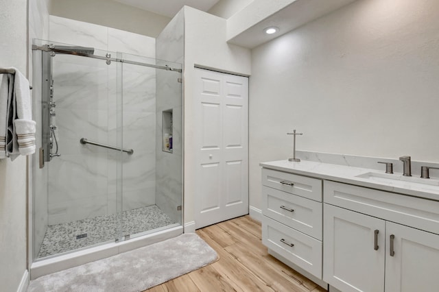 bathroom with walk in shower, hardwood / wood-style flooring, and vanity