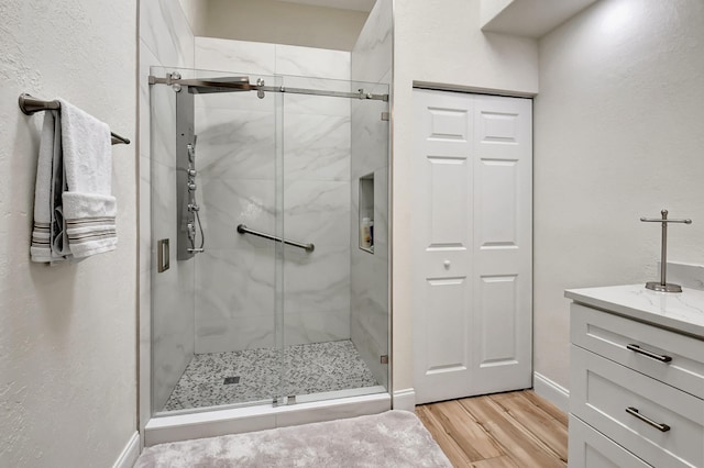 bathroom featuring vanity, wood-type flooring, and walk in shower