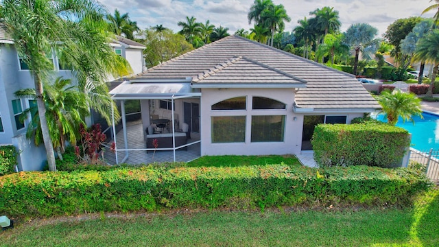 rear view of house with a patio area and a sunroom