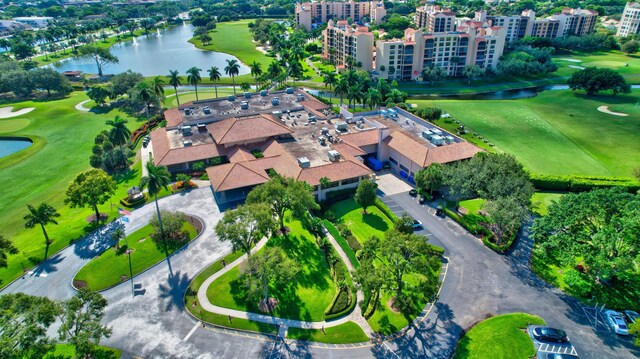 drone / aerial view with a water view, golf course view, and a city view