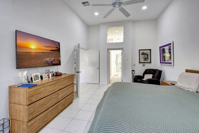 bedroom with light tile patterned floors, ceiling fan, and a high ceiling