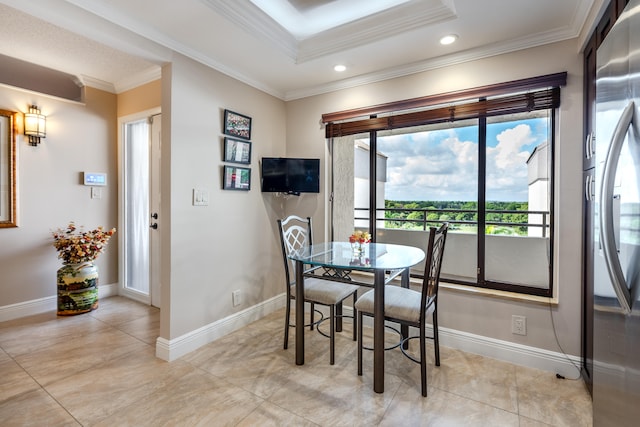 dining room with a tray ceiling, light tile patterned flooring, and ornamental molding