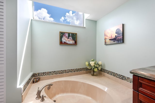 bathroom featuring a tub to relax in and vanity