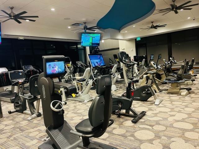 exercise room featuring ceiling fan and light colored carpet