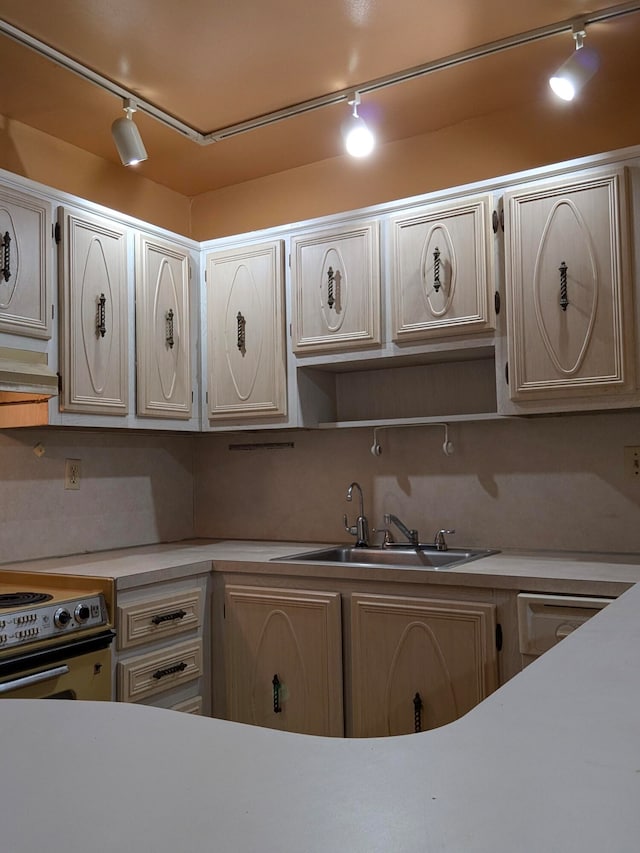 kitchen with sink, rail lighting, and electric range oven