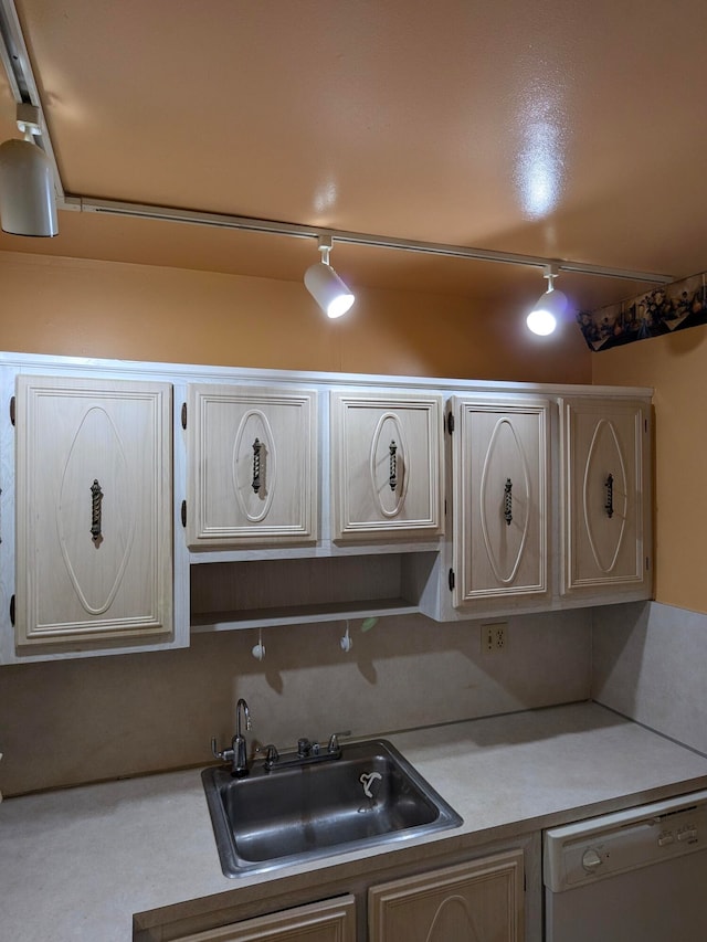 kitchen with dishwasher, sink, and rail lighting