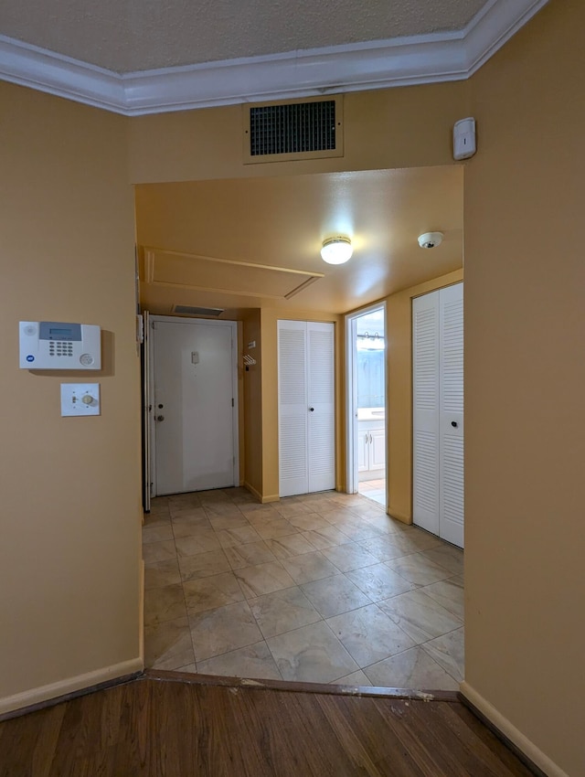 corridor featuring crown molding and light hardwood / wood-style flooring