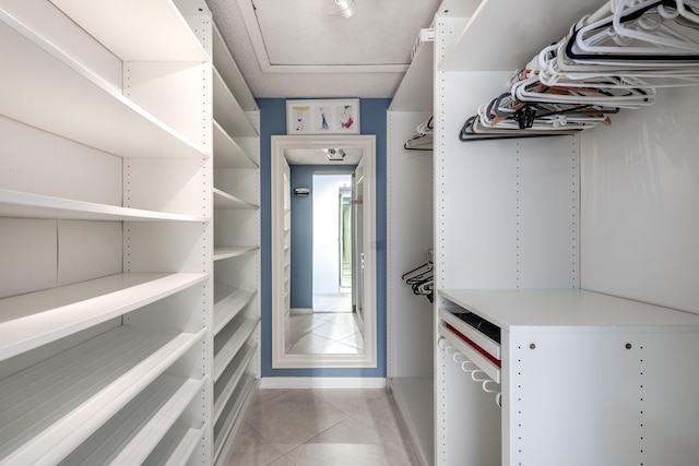 walk in closet featuring light tile patterned flooring