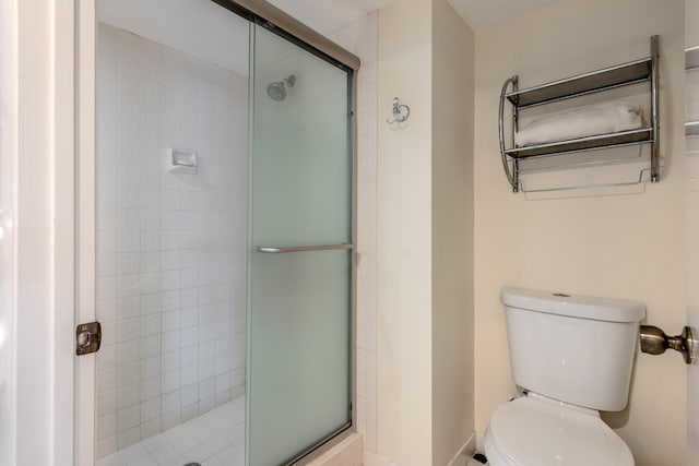 bathroom with a shower with door and toilet