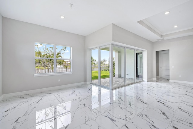 tiled empty room featuring a tray ceiling